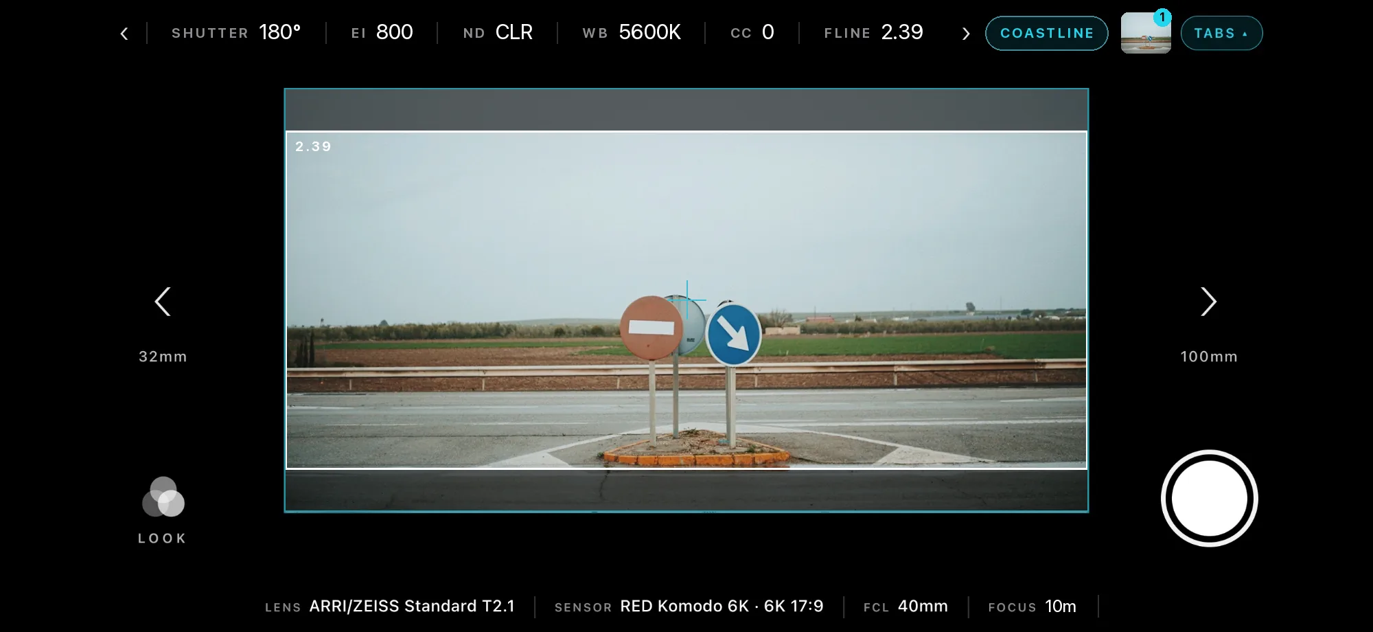 Viewfinder framing road signs on a traffic island in open country at 2.39, with camera settings across the top and the lens and sensor below